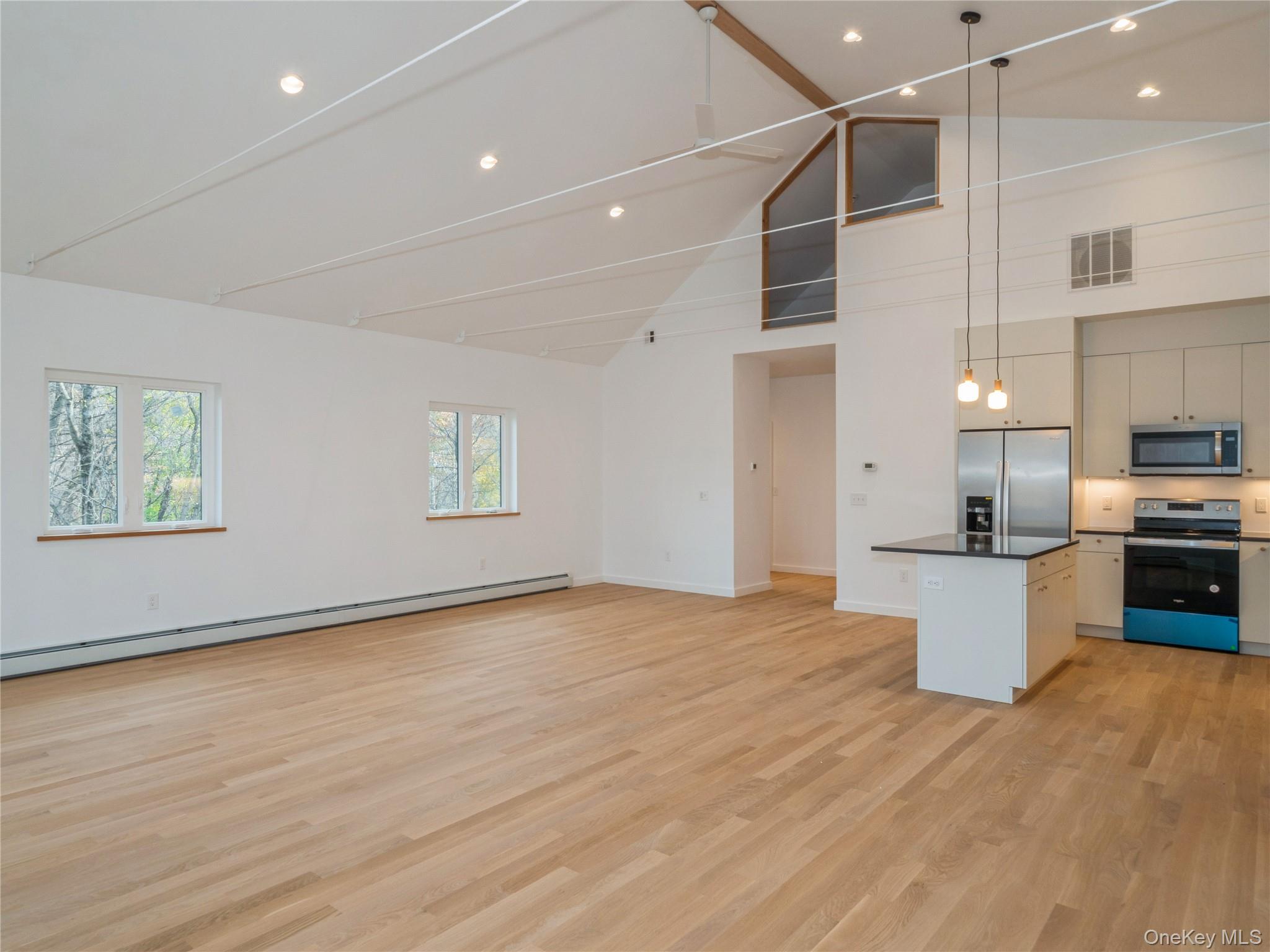50 Old Albany Post Road North, Unit #1 Cold Spring, NY 10516 - Photo 7 of 18 a view of a kitchen with stainless steel appliances a large counter top and wooden floor