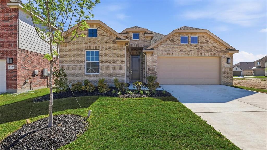2529 Rivers W Road Anna, TX 75409 - Photo 5 of 40 Traditional brick facade residence featuring a two-car garage, concrete driveway, and established landscaping