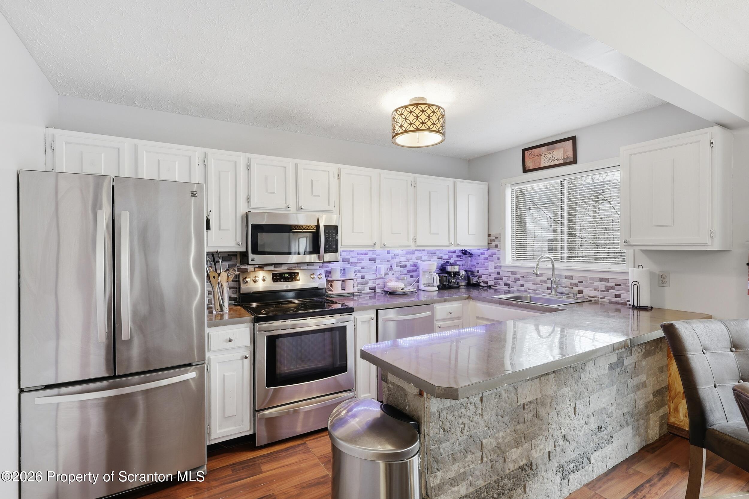 1379 Winding Way Tobyhanna, PA 18466 - Photo 11 of 51 a kitchen with granite countertop a stove a sink dishwasher a refrigerator and a oven with wooden floor