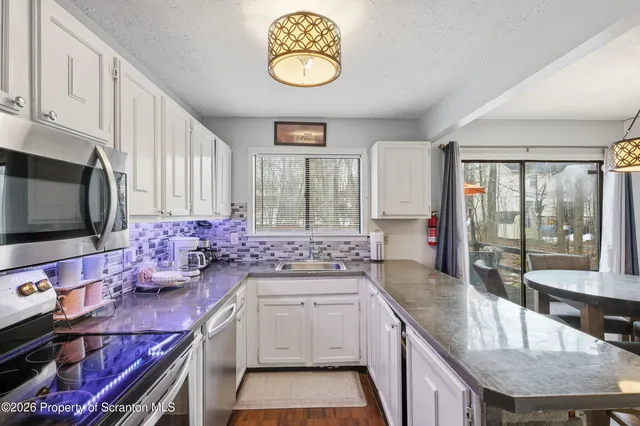 a kitchen with stainless steel appliances granite countertop a sink stove and cabinets