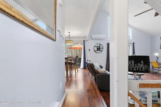 a view of a hallway with chairs and wooden floor