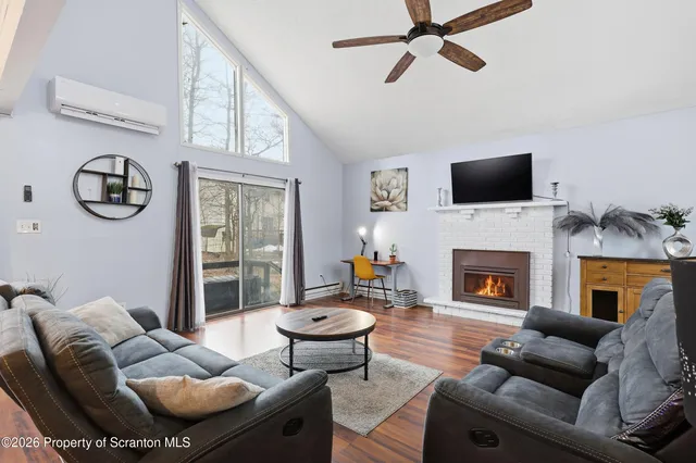 a living room with furniture a fireplace and a flat screen tv