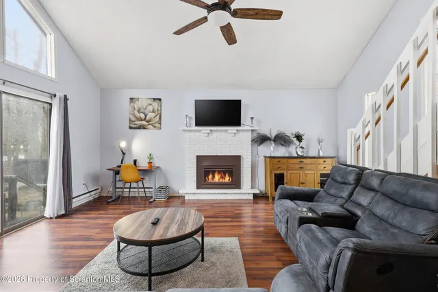 a living room with furniture a flat screen tv and a fireplace