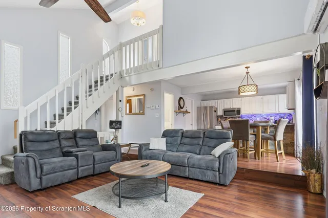 a living room with furniture a fireplace and wooden floor