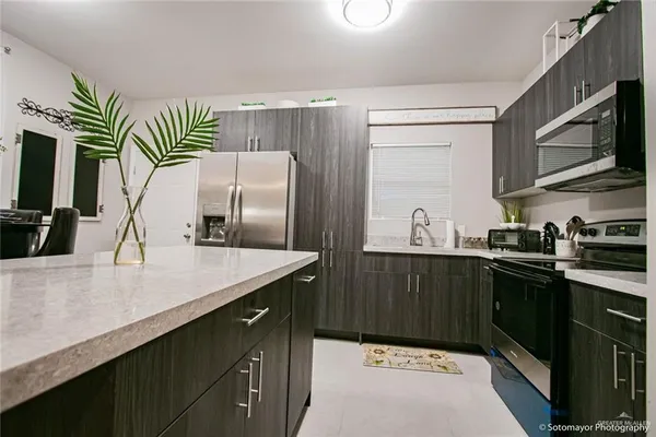 a kitchen with stainless steel appliances a sink and a refrigerator