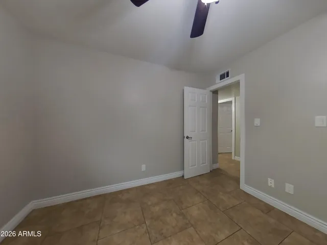 an empty room with windows and fan