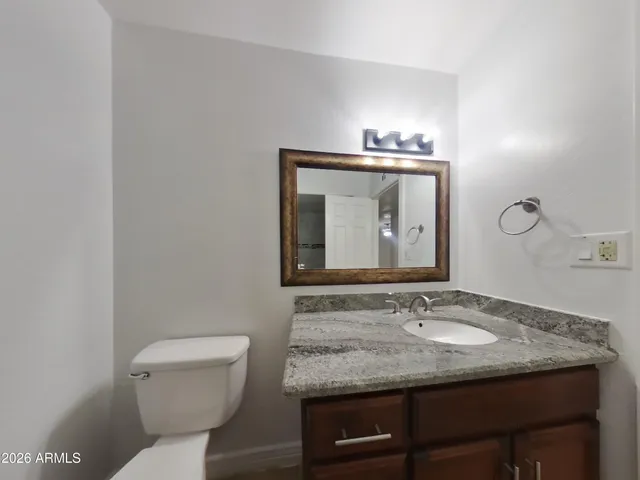 an empty room with a chandelier fan and windows