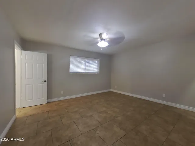a view of an empty room with a chandelier fan