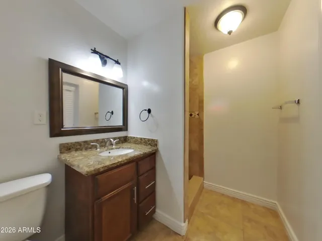 an empty room with windows and chandelier fan