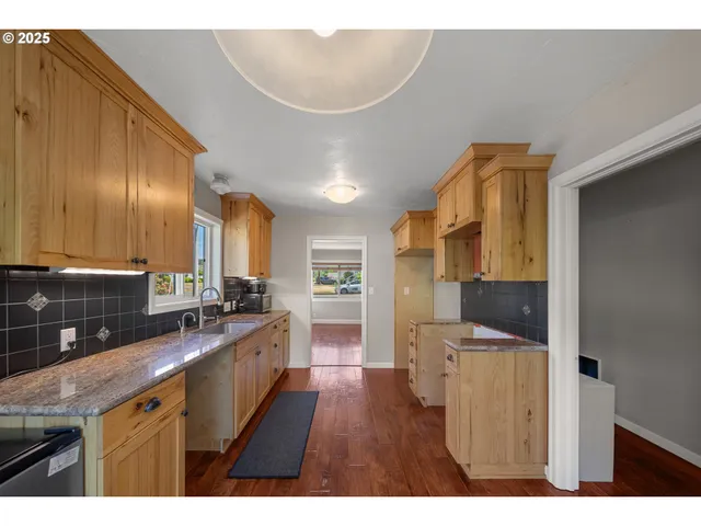 a kitchen with stainless steel appliances granite countertop a sink stove and cabinets