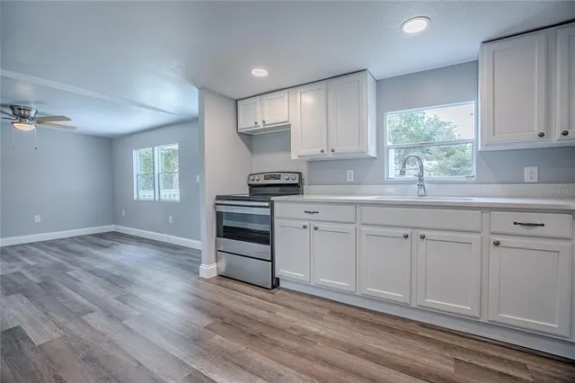 a kitchen with granite countertop white cabinets and window