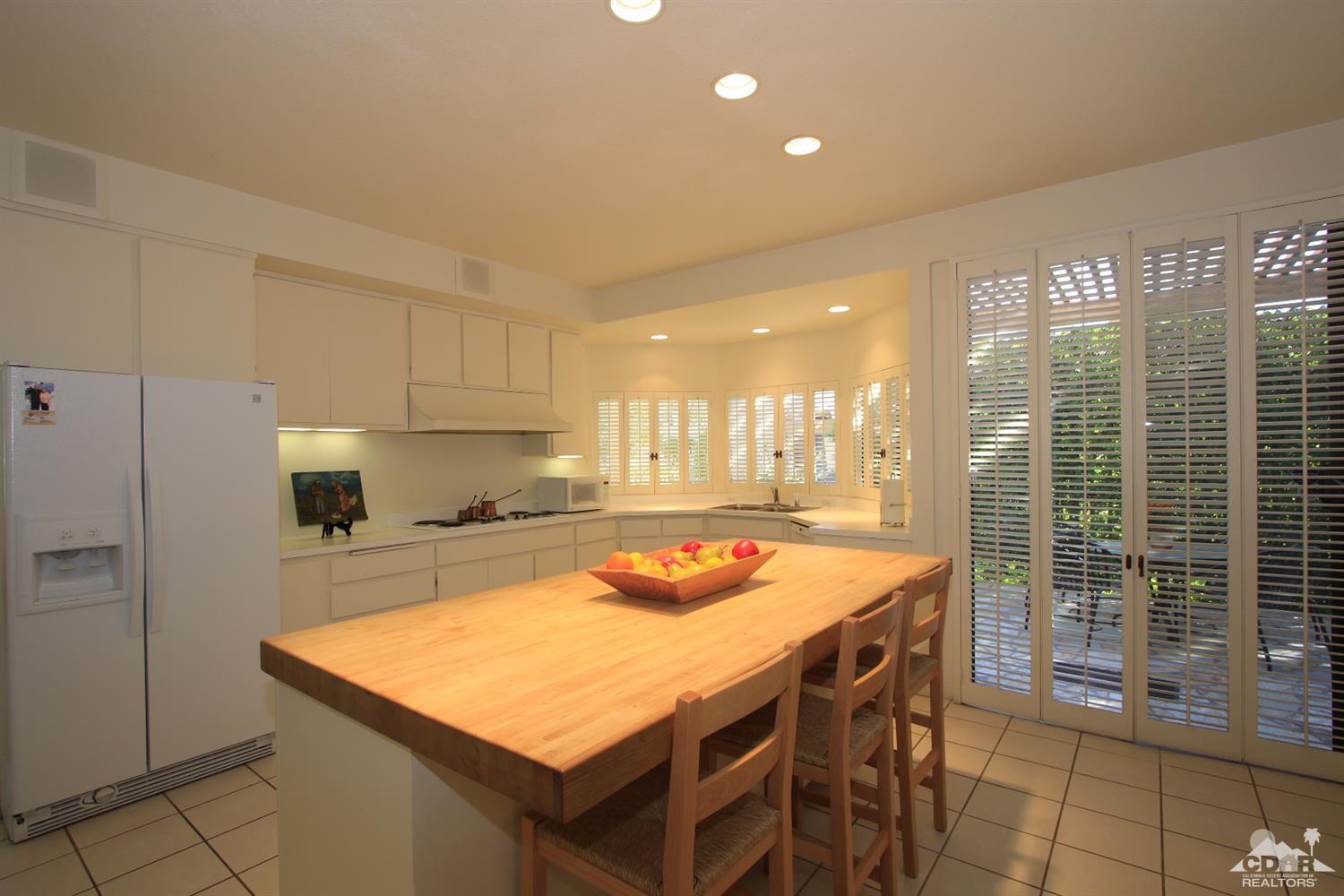 927 Inverness Drive Rancho Mirage, CA 92270 - Photo 17 of 42 a kitchen with stainless steel appliances granite countertop a stove a refrigerator a sink a dining table and chairs