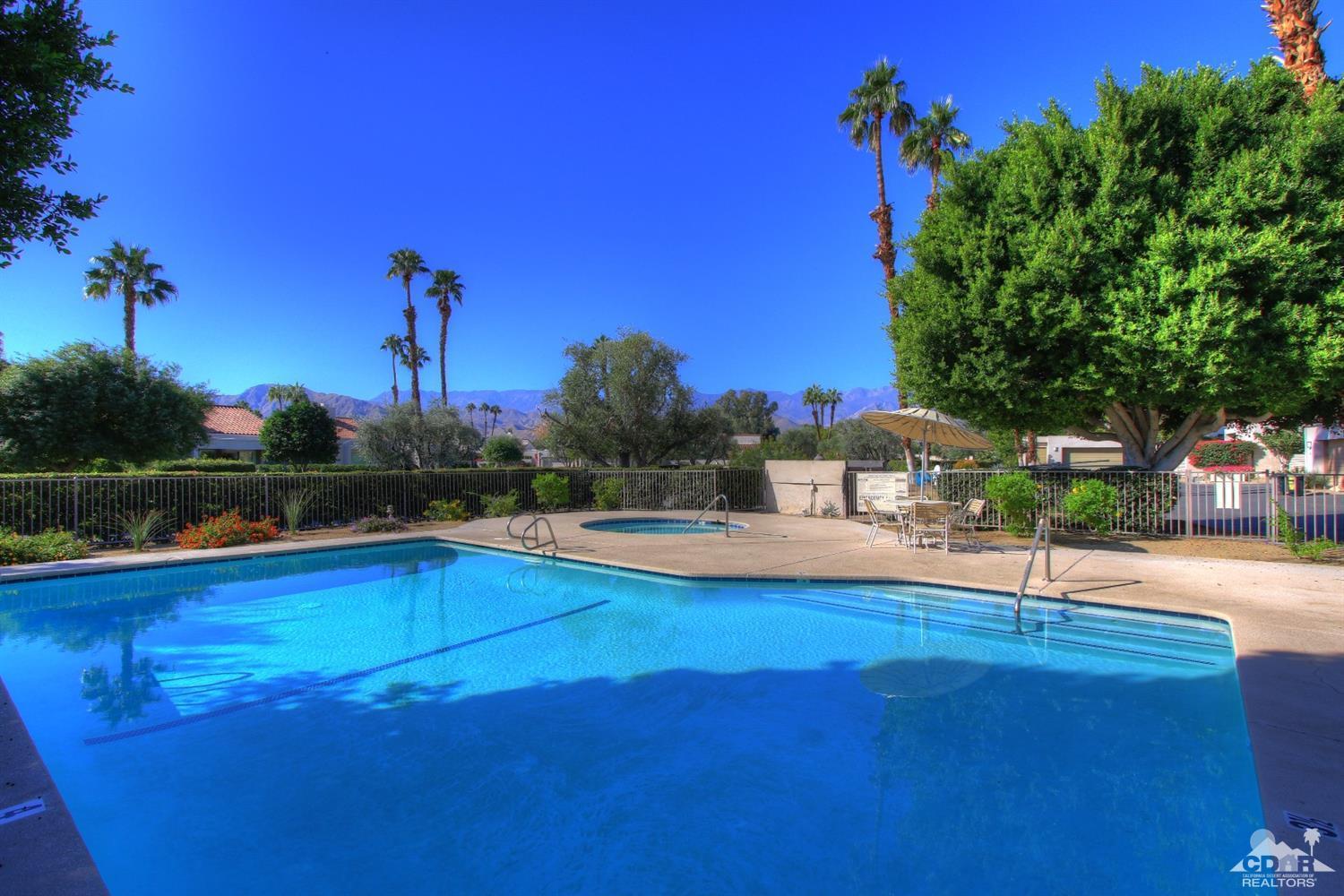 927 Inverness Drive Rancho Mirage, CA 92270 - Photo 41 of 42 a view of a swimming pool with a table and chairs under an umbrella