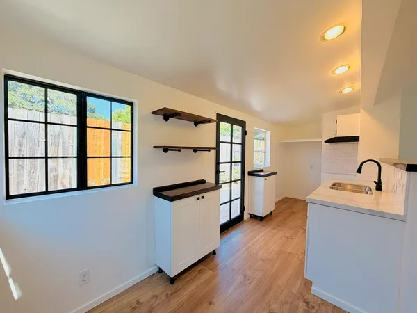 a view of a kitchen with a sink and dishwasher with wooden floor