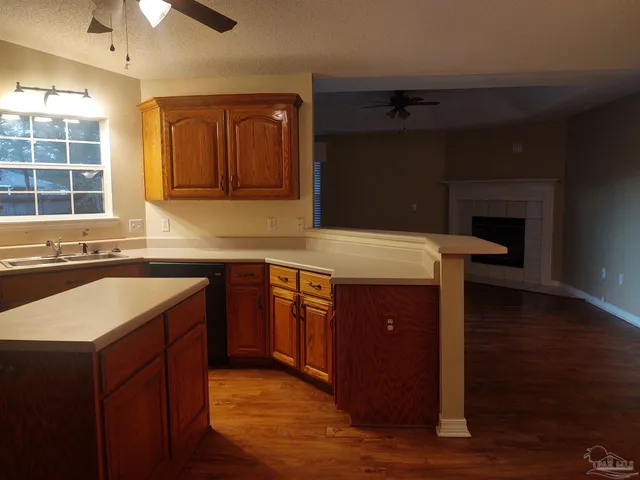 a kitchen with a sink cabinets and wooden floor
