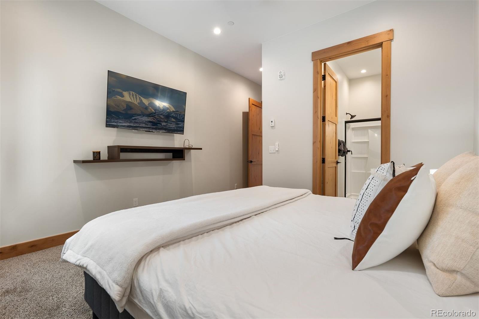 72 Meadow Trail, Unit F102 Fraser, CO 80442 - Photo 17 of 35 a bedroom with a bed and a flat screen tv