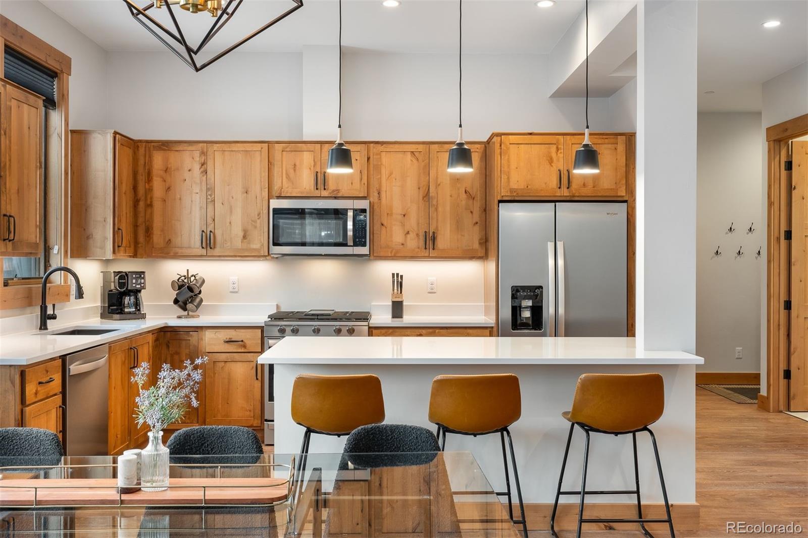 72 Meadow Trail, Unit F102 Fraser, CO 80442 - Photo 4 of 35 a kitchen with stainless steel appliances granite countertop a table chairs refrigerator and sink