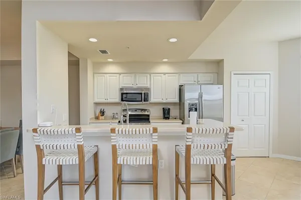 a kitchen with stainless steel appliances kitchen island granite countertop a refrigerator and microwave