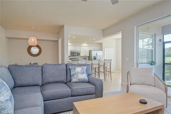 a living room with furniture and a view of kitchen