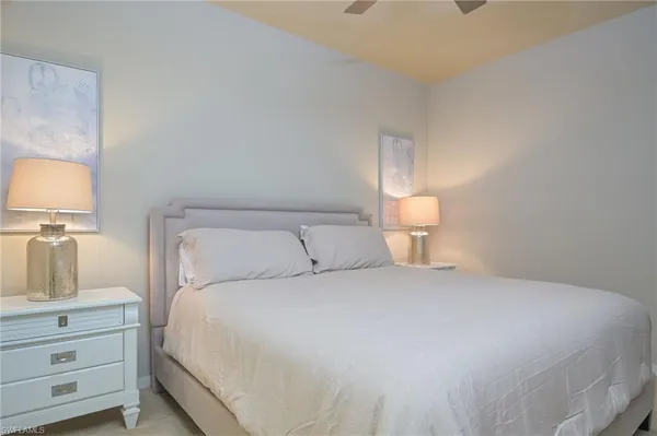 a bedroom with a bed and a lamp on dresser