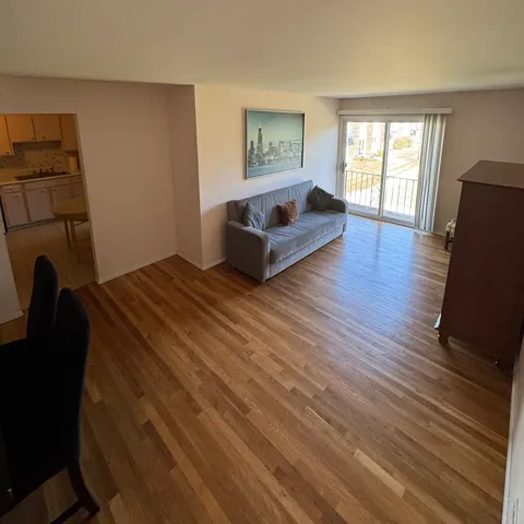 a spacious bedroom with a bed and wooden floor