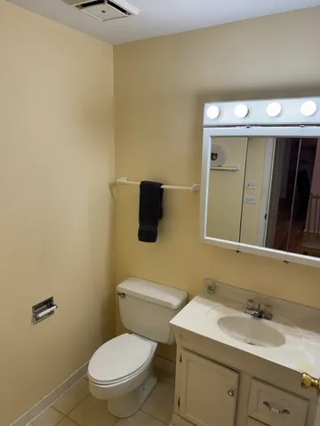a bathroom with a toilet a sink and mirror