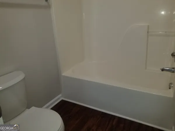 an empty room with wooden floor and a sink