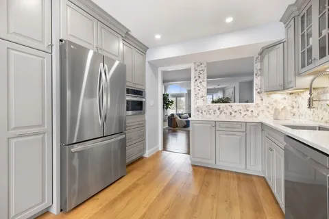 a kitchen with stainless steel appliances a refrigerator sink and microwave
