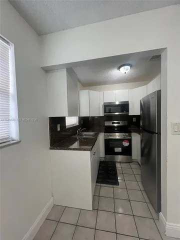 a kitchen with a sink a stove and cabinets