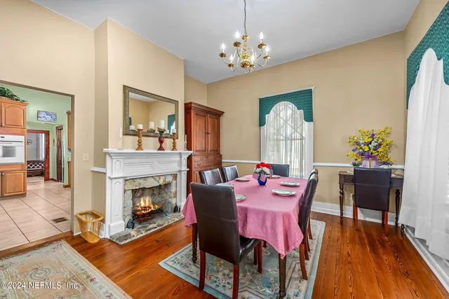 a dining room with furniture a fireplace and wooden floor