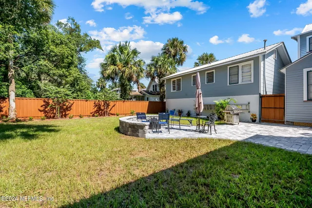 a view of a house with backyard and sitting area