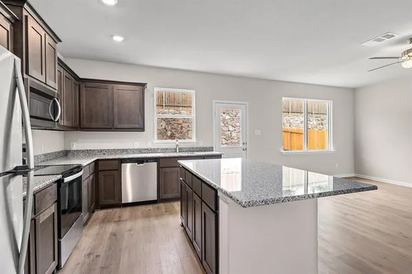 a kitchen with stainless steel appliances granite countertop a sink and stove top oven