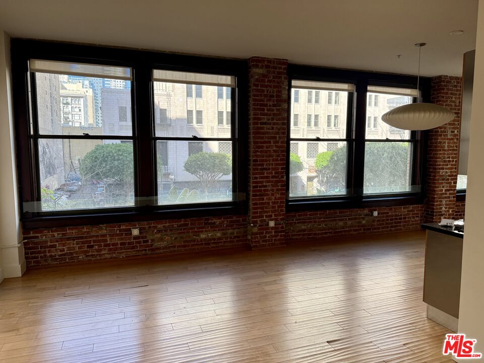 a view of a room with wooden floor and floor to ceiling window