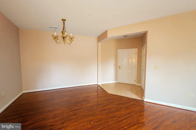 a view of empty room with wooden floor and window