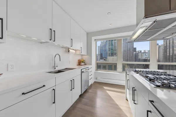 a kitchen with stainless steel appliances a sink stove and cabinets