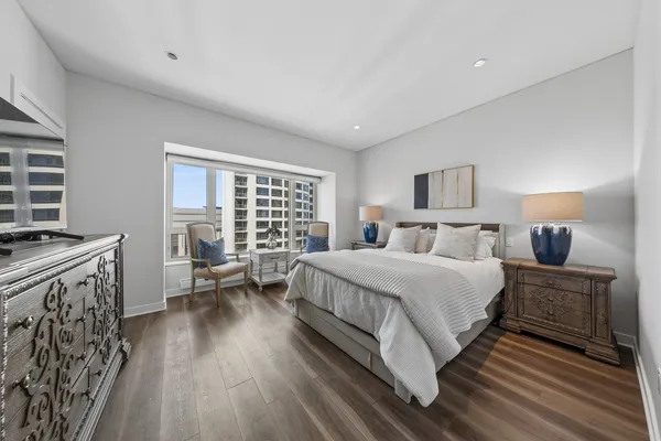 a spacious bedroom with a bed a couch and dresser