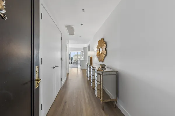 a view of a hallway with wooden floor and staircase
