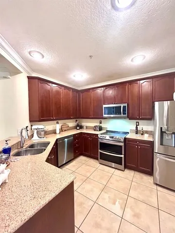 a kitchen with stainless steel appliances granite countertop a sink counter space cabinets and a stove