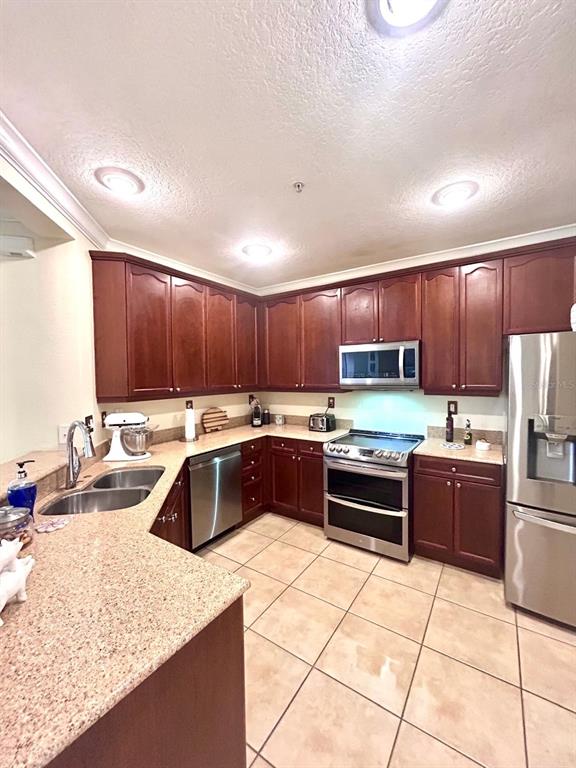 8168 Boat Hook Loop, Unit 107 Windermere, FL 34786 - Photo 11 of 25 a kitchen with stainless steel appliances granite countertop a sink counter space cabinets and a stove