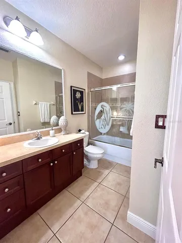 a spacious bathroom with a granite countertop sink toilet and shower