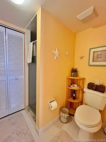 a bathroom with a toilet and a shower