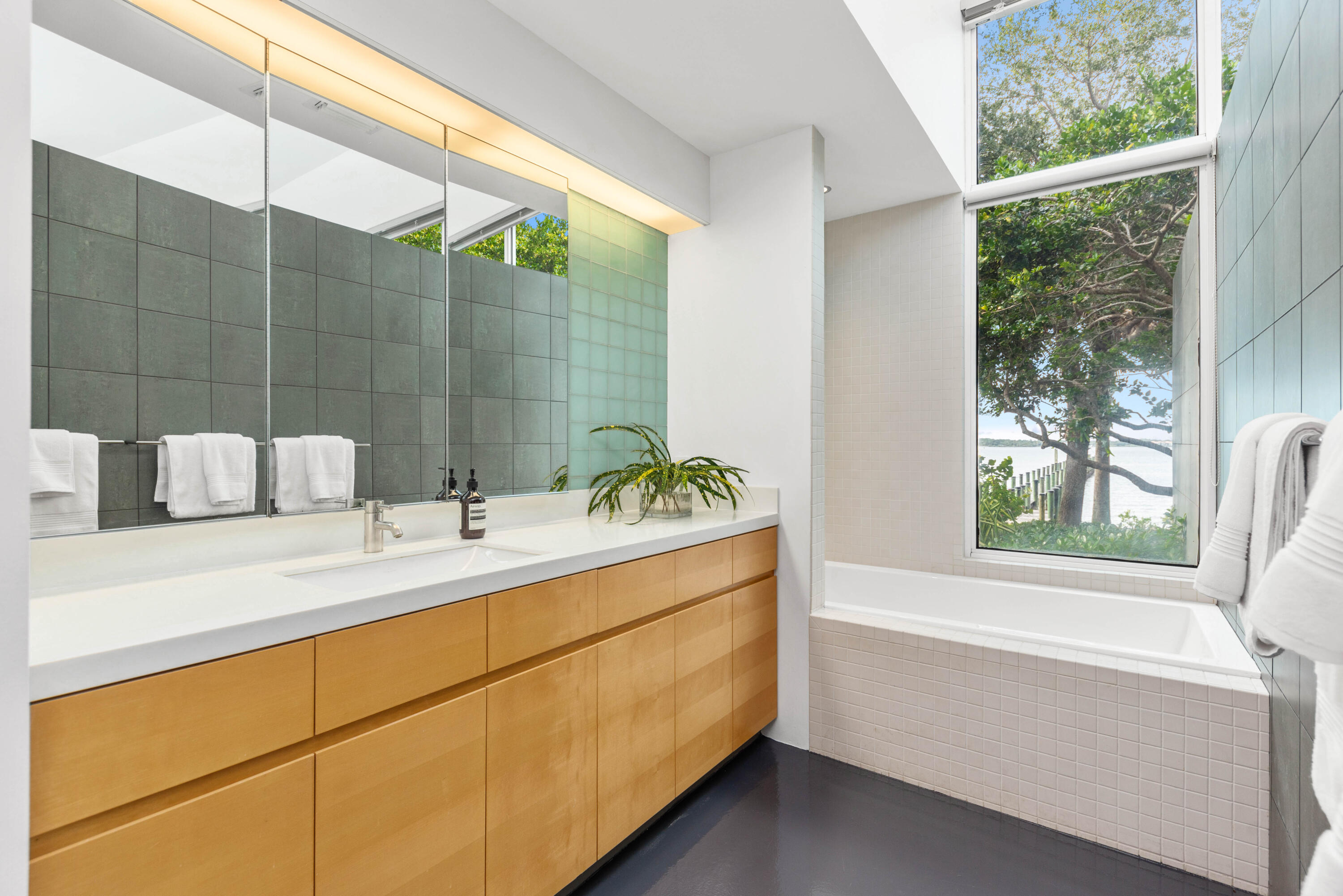 1924 Northwest Shore Terrace Stuart, FL 34994 - Photo 23 of 33 a bathroom with a tub sink and mirror