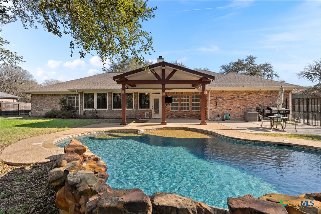 a view of a house with swimming pool and sitting area