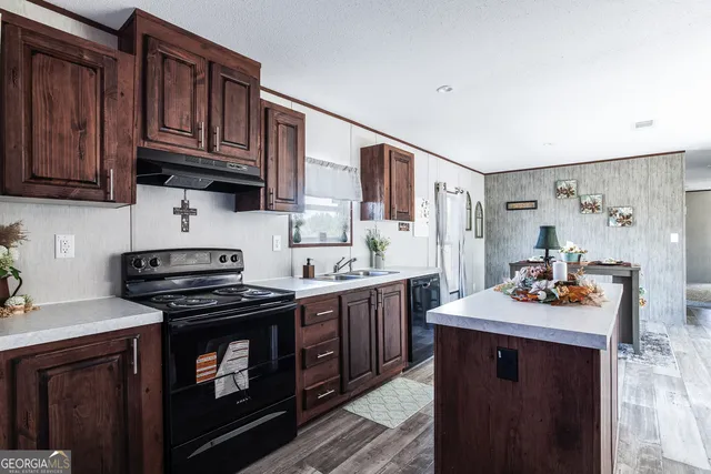 a kitchen with stainless steel appliances wooden cabinets and a stove top oven