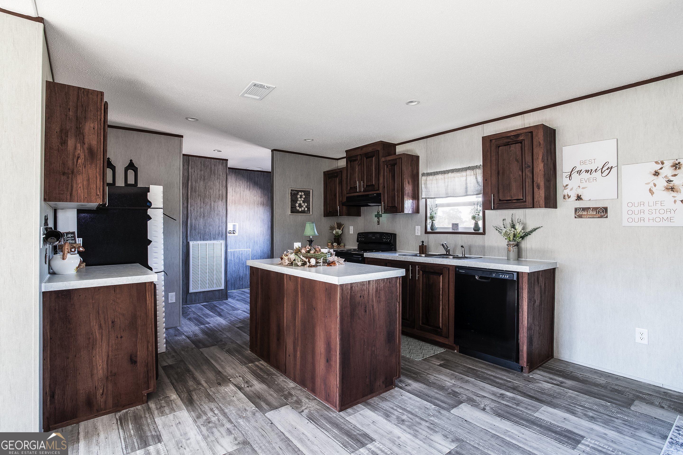 373 Barber Branch St. George, GA 31562 - Photo 8 of 30 a kitchen with stainless steel appliances granite countertop a stove top oven a refrigerator a sink and dishwasher with wooden floor