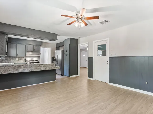 a view of a kitchen with wooden floor and a sink