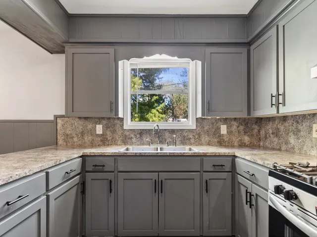 a kitchen with a sink stove and cabinets
