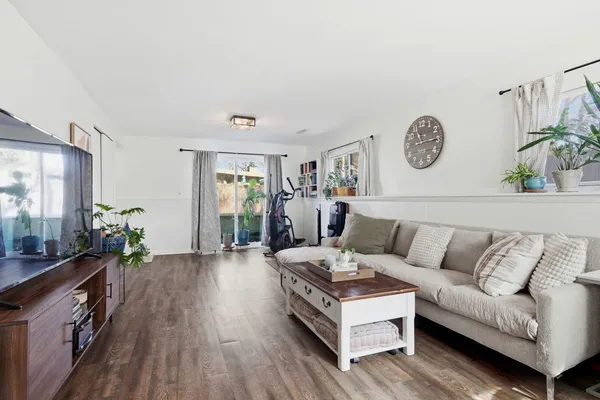a living room with furniture and wooden floor