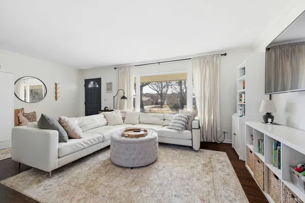 a living room with furniture and a large window with garden view
