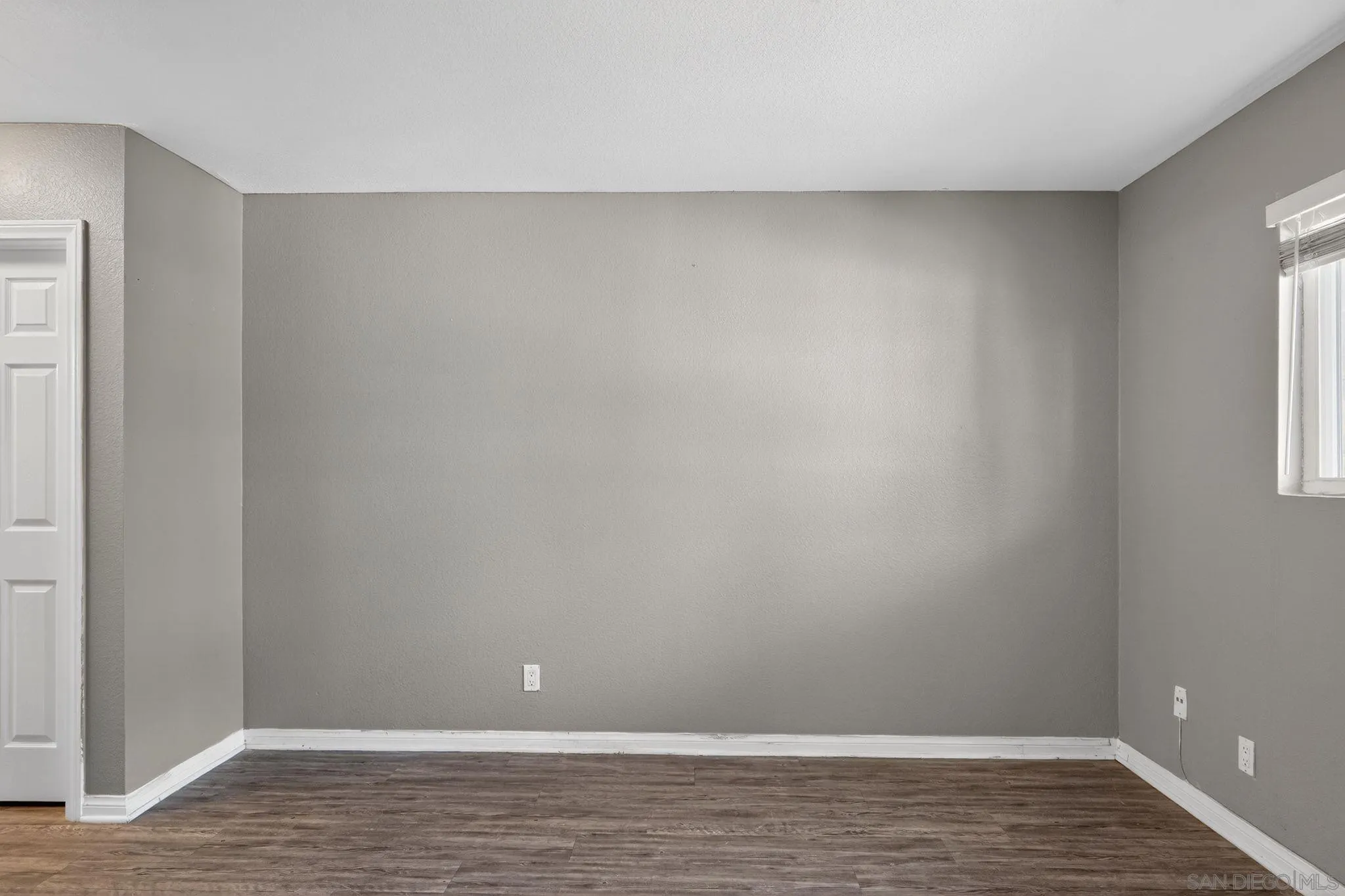 9860 Dale Avenue, Unit B9 Spring Valley, CA 91977 - Photo 16 of 31 a view of an empty room with wooden floor and a window